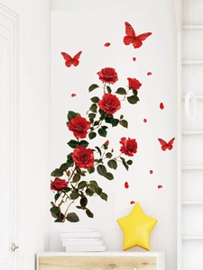 Close-up of red rose wall decals and butterflies on white wall above a wooden cabinet