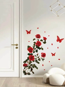 Detail view of red rose and butterfly PVC wall decals on a minimalist white living room wall