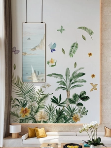 Détail de stickers muraux tropicaux avec feuilles de bananier et papillons dans un salon