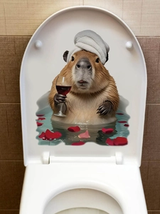 Close-up of a cute capybara wall sticker on a toilet lid with red rose petals