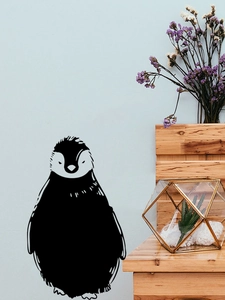 Detailed view of black penguin wall stickers on a blue wall in a minimalist room
