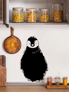 Detail of cute black penguin wall sticker applied on a clean kitchen backsplash surface