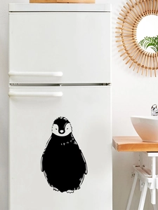 Macro detail of black penguin wall stickers on a white refrigerator in a modern kitchen