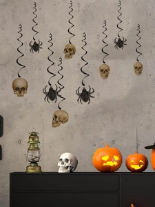 Hanging Halloween PVC swirl decorations with skull and spider charms on concrete wall