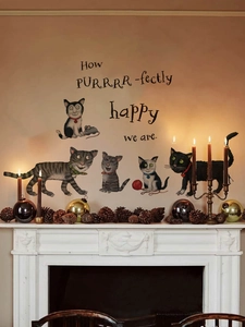 Halloween cartoon cats wall stickers with quote displayed above a cozy fireplace