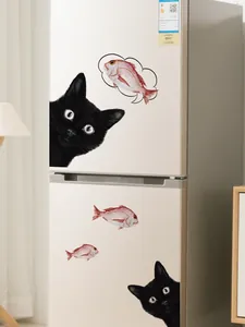 Peeking black cat wall decal with fish applied on a white refrigerator surface