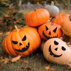 Halloween pumpkin face stickers on natural pumpkins for festive outdoor wall decor