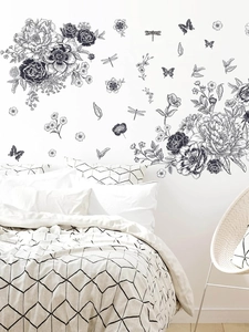 Détail d'un sticker mural croquis avec des pivoines et des papillons sur un mur blanc de chambre