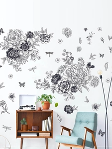 Détail d'un sticker mural croquis de papillons et fleurs sur un mur blanc épuré