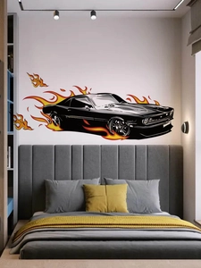 Détail d'un sticker mural voiture de course noire avec flammes orange au-dessus d'un lit