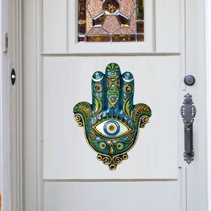 Décoration murale Main de Fatima avec motif œil bleu sur fond de porte en bois blanc