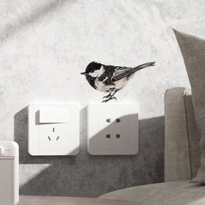 Realistic black and white bird wall sticker placed above a white light switch