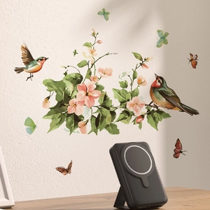 Batterie externe magnétique noire avec support pliable sur table devant des stickers muraux
