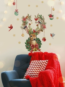 Close-up of Christmas reindeer wall decal with pine branches and bells on white wall