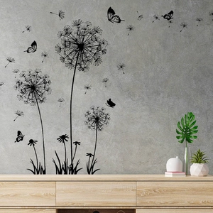 Black dandelion and butterfly wall stickers on grey wall above a wooden TV stand