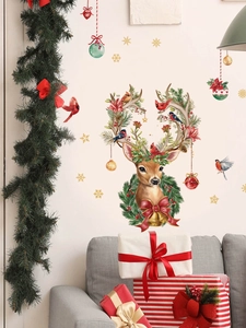 Close-up of Christmas reindeer wall decal with red flowers and ornaments on a white wall