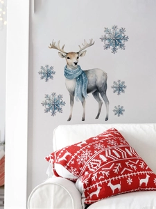 Détail d'un sticker mural renne bleu et flocons de neige sur un mur gris salon