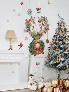 Detail of Christmas reindeer wall stickers with red birds and gold snowflakes on a white wall