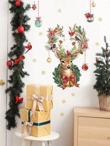 Close-up of Christmas reindeer wall decal with pine needles and red berries on white wall