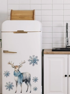 Stickers renne bleu et flocons de neige sur un réfrigérateur blanc dans la cuisine