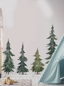 Detail of watercolor pine tree wall decals in a cozy nursery room with a play tent