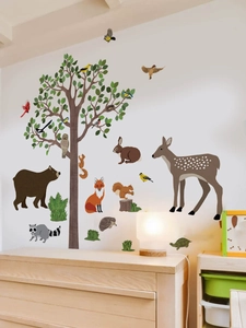 Detail of forest animal wall decals showing a large tree and woodland creatures on a white wall
