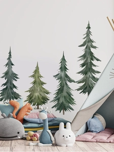 Detail of watercolor pine tree wall stickers in a cozy nursery room setting