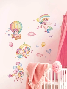 Detailed view of unicorn and hot air balloon wall decals in a cozy pink nursery setting