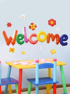 Close-up of colorful 3D rainbow balloon letters spelling Welcome and floral wall stickers
