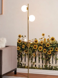 Détail de deux globes en verre et plateau doré sur lampadaire moderne avec mur de tournesols