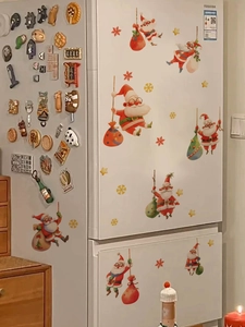 Détail de stickers de Noël Père Noël avec flocons dorés sur un réfrigérateur blanc