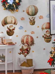 Détail de stickers muraux de Noël montrant le Père Noël en montgolfière sur un mur blanc