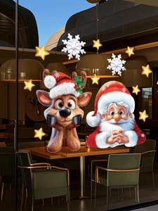 Detail of Santa and reindeer window stickers on glass with snow and star decorations