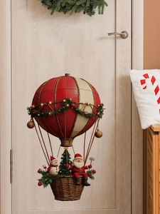 Detail of Santa hot air balloon wall hanging with LED lights on a wooden door