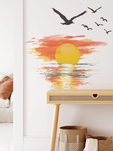 Artistic sunset wall decal with birds displayed above a minimalist console table