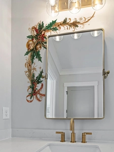 Close-up of PVC Christmas wall sticker with holly leaves and red berries on a white bathroom wall