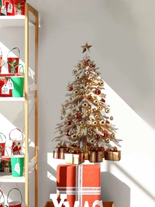 Detail of a white mini Christmas tree with gold ornaments and a star on a red gift box base