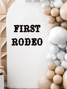 Detail of First Rodeo white arch backdrop with black lettering and balloon garland décor