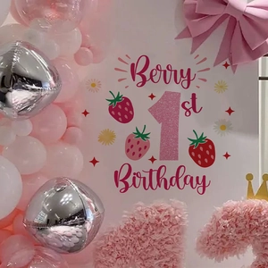 Pink strawberry berry first birthday party backdrop with balloons and daisy floral accents