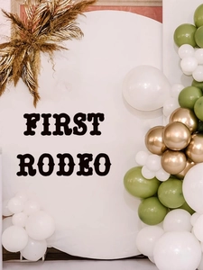 Detail of sage green, white, and gold balloon arch kit with palm leaves for party
