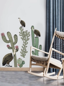 Detailed wall sticker layout with cactus and vulture on white wall beside wooden rocker