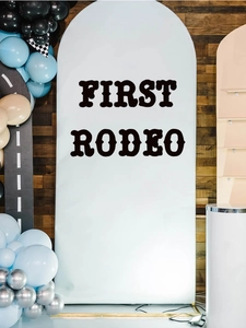 Detail view of First Rodeo light blue arch backdrop with black artistic typography