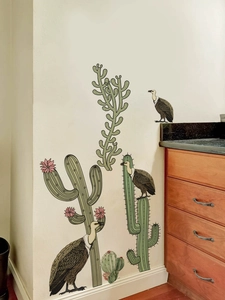 Detail of self-adhesive cactus and vulture wall decals on a white living room wall