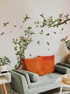 Detail of artistic hummingbird and green leaf wall stickers in a modern living room setup