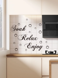 Close-up of Soak Relax Enjoy black waterproof PVC wall decals on white bathroom tiles