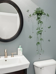 Detail of green floral wall sticker with hanging vines and butterflies in a bathroom