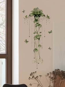 Detail of green floral wall stickers featuring vines, beads, and 3D butterflies on a beige wall