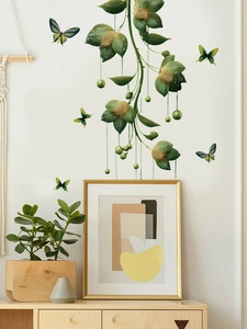 Detail of green vine and butterfly wall stickers on a white wall in a modern living room