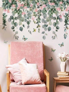 Detail of butterfly wall stickers with green vines and pink flowers on a white wall