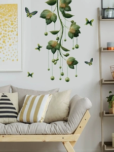 Detail of hanging green plants and butterfly wall stickers on living room sofa wall